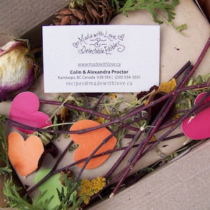 May include: A business card with the text "Made with Love - Delectable Edibles" and a website address. The card is surrounded by dried flowers, twigs, and hearts.