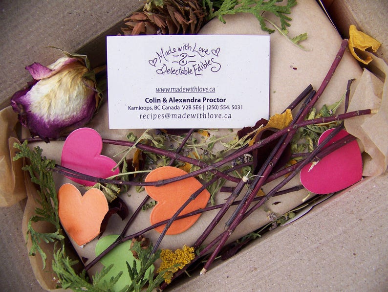 May include: A business card with the text "Made with Love - Delectable Edibles" and a website address. The card is surrounded by dried flowers, twigs, and hearts.