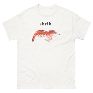 May include: A white short-sleeved t-shirt featuring a graphic of a red shrimp with a cigarette in its mouth. Above the shrimp, the text "shrih" is printed in a simple black serif font. The design is centred on the chest of the garment.
