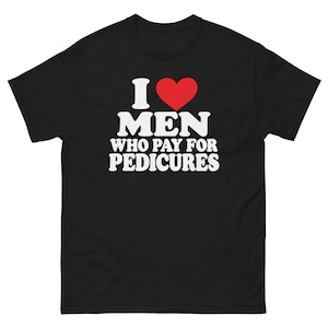 Könnte beinhalten: Ein schwarzes Kurzarm-T-Shirt mit weißem Text, der I liest, einem roten Herzsymbol und den Worten MEN WHO PAY FOR PEDICURES. Die Grafik ist mittig auf der Brust des T-Shirts platziert, das einen Rundhalsausschnitt und einen geraden Saum hat.
