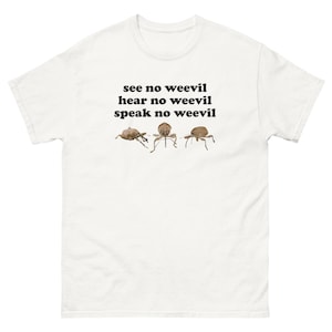 Op de afbeelding: Een wit t-shirt met korte mouwen en een afbeelding van drie bruine snuitkevers op een rij. Boven de insecten staat de zwarte tekst: see no weevil, hear no weevil, speak no weevil. Het t-shirt heeft een ronde hals en een standaard pasvorm.