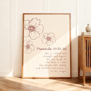 Może przedstawiać: Oprawiony wydruk z ilustracjami kwiatowymi i tekstem z Księgi Przysłów 31:25-26. Grafika ma kremowe tło z brązowymi konturami kwiatów i tekstem. Rama jest w ciepłym brązowym kolorze.