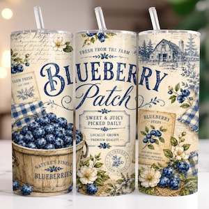 May include: A cylindrical tumbler with a straw featuring a vintage-style design with blue and cream colors. The print displays blueberries in a wooden bucket, a barn, and text including "BLUEBERRY Patch," "FRESH FROM THE FARM," and "SWEET & JUICY."