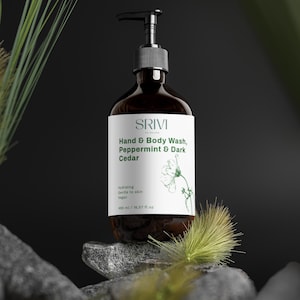 May include: A dark brown bottle of SRIVI Hand & Body Wash, Peppermint & Dark Cedar, with a black pump dispenser. The label is white with green text and a botanical illustration. The bottle is 490 ml / 16.57 fl oz.