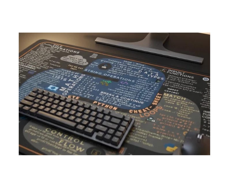 May include: A black computer keyboard sits on a black and grey mousemat. The mousemat displays a Python cheat sheet with text and diagrams. A computer monitor base is visible in the background.