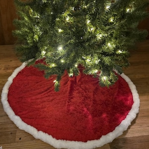 Hand Crafted Christmas Tree Skirt. Top color is crushed Red Velvet and the bottom Red Satin. The tree skirt is 43 inches in circumference.