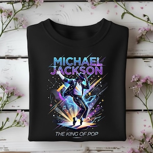 Può includere: Felpa girocollo nera con una grafica vibrante di Michael Jackson. Il design include il testo "MICHAEL JACKSON" e "THE KING OF POP" in uno stile neon colorato, con note musicali e scoppi di stelle. L'immagine raffigura Jackson in una posa di danza.