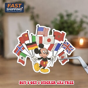 May include: A die-cut sticker featuring a cartoon mouse with black ears, red shorts, and yellow shoes, holding a cluster of various international flags on thin poles. The text at the bottom reads: BUY 5 GET 1 STICKER 2X2 FREE. The design has a vintage, distressed texture.