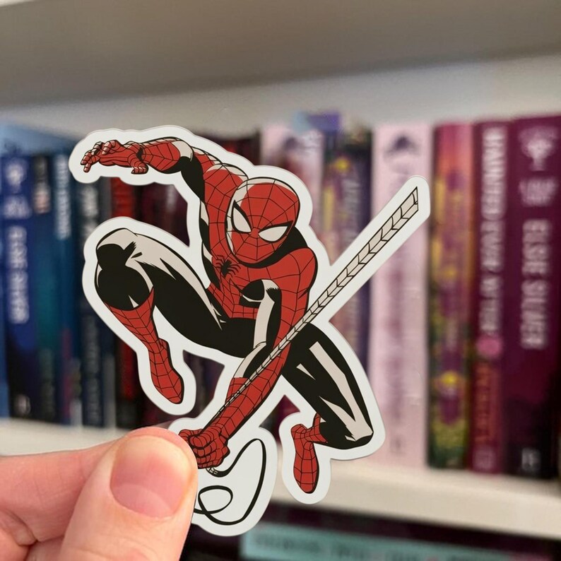 May include: A sticker depicting Spider-Man in a dynamic pose, wearing his classic red and black suit. The sticker shows the superhero with a web-shooter, ready for action. The design is a vibrant illustration, ideal for fans of comic books and superheroes.