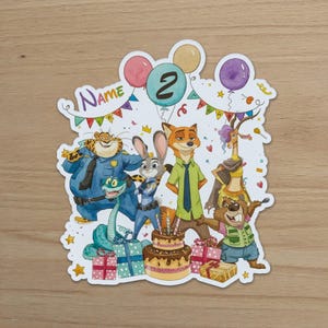 May include: A die-cut sticker featuring a watercolour illustration of Zootopia characters including a cheetah, rabbit, fox, gazelle, and beaver. The design includes a birthday cake with candles, colourful balloons, gift boxes, and the text Name and 2.