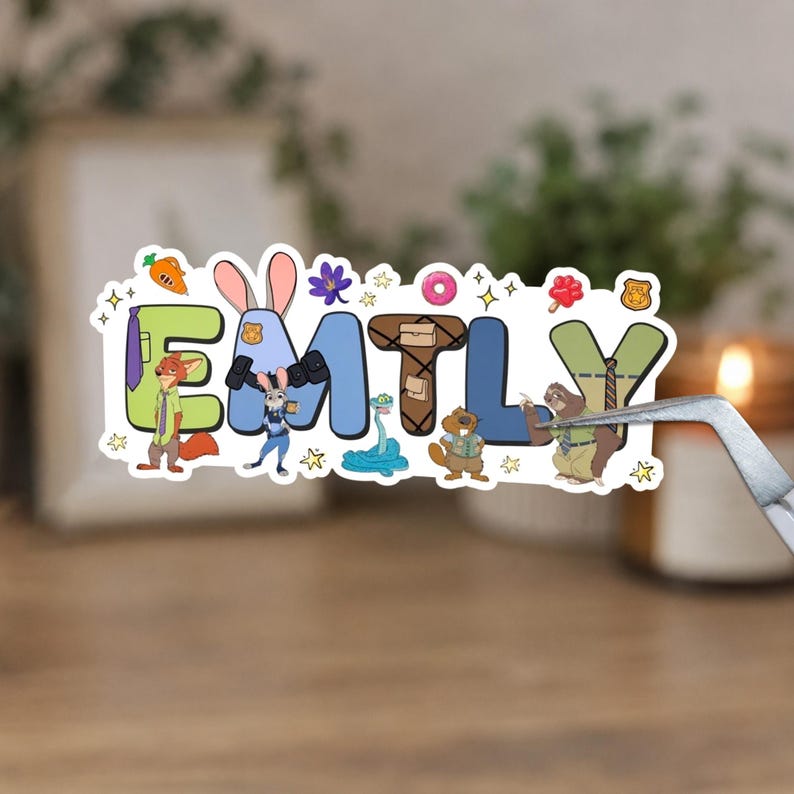May include: A die-cut sticker featuring the name EMILY spelled out with Zootopia-themed characters and icons. The letters are decorated with a fox, a rabbit, a snake, a beaver, and a sloth, alongside small illustrations of a carrot, donut, and badge.