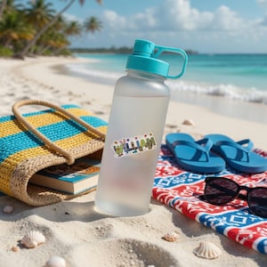 May include: A frosted clear plastic water bottle with a teal screw-top lid and handle. A sticker on the bottle features the name WILLIAM in colorful, stylized block letters decorated with small floral and nature-themed graphic elements.