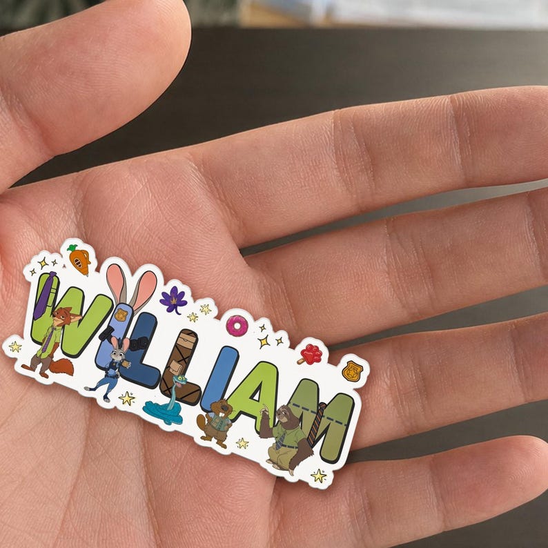 May include: A die-cut sticker featuring the name WILLIAM in large, colorful, block-style letters. The design incorporates various animated animal characters and small icons like a carrot, a flower, a donut, and a badge scattered around the text.