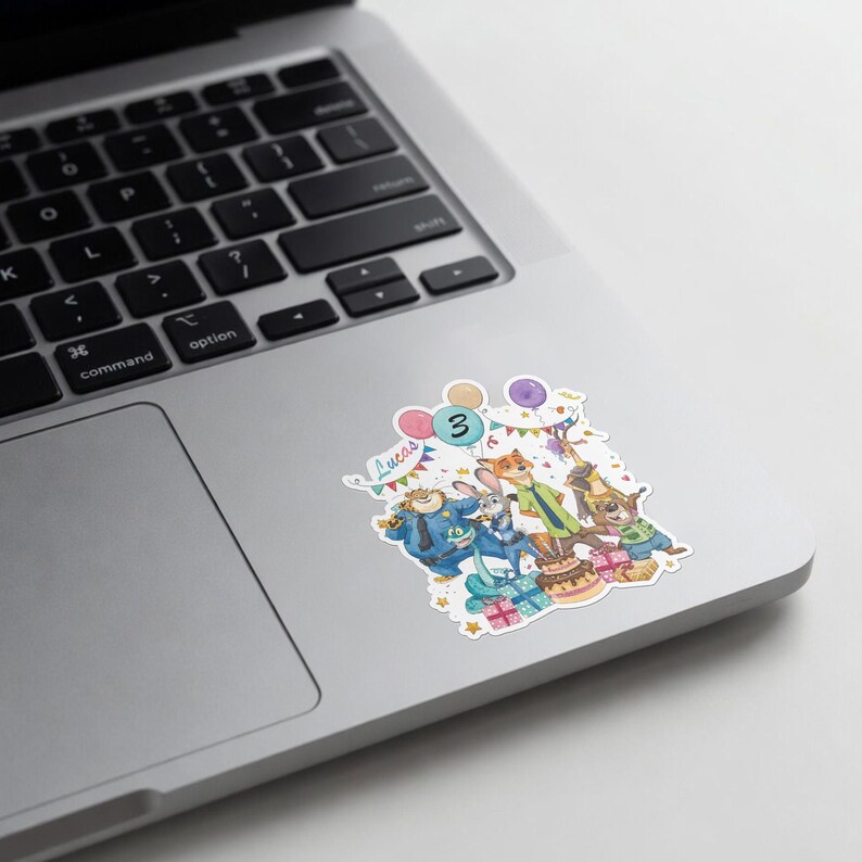 May include: A sticker featuring Zootopia characters including Judy Hopps, Nick Wilde, Chief Bogo, and Flash, with a birthday cake, balloons, and the name Lucas written in cursive. The number 3 is displayed prominently above the characters.