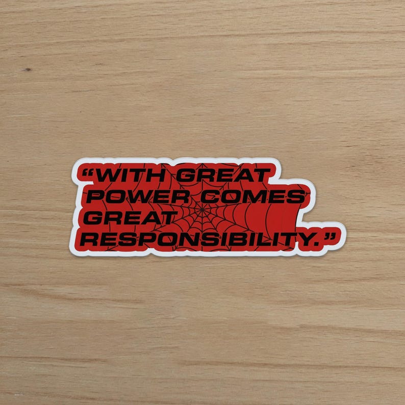 May include: A red sticker with the quote "WITH GREAT POWER COMES GREAT RESPONSIBILITY." The text is in black, with a spiderweb design in the center. The sticker has a white border.