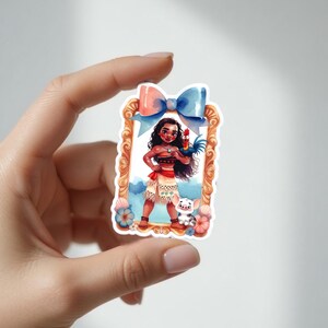 May include: A sticker featuring a watercolor illustration of a character with long black hair, a red and white outfit, and a rooster. The character is standing in a decorative frame with a blue bow at the top. A small pig is also in the image.