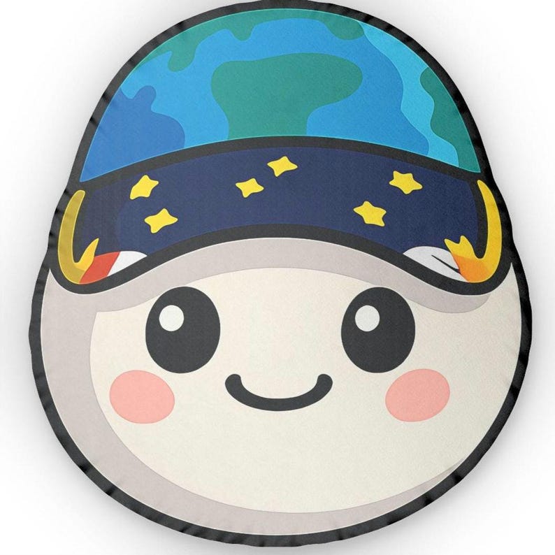 May include: A round, cartoon-style pillow featuring a smiling face with rosy cheeks. The pillow's design includes a blue and green Earth-like helmet with yellow star accents, and a dark blue band. The pillow has a black border.