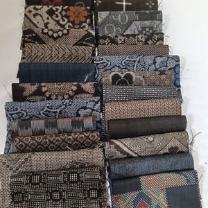 Könnte beinhalten: Eine Sammlung gefalteter Stoffmuster, die in zwei Spalten angeordnet sind und eine Vielzahl von Webmustern aufweisen, darunter geometrische Formen, florale Motive und Punkte in Braun-, Blau-, Schwarz-, Weiß- und bunten Farbtönen.
