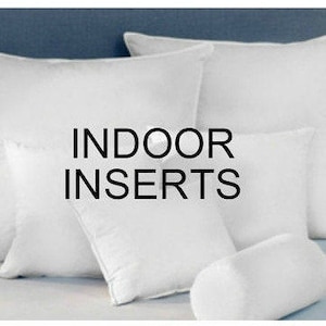 May include: A set of white pillow inserts, including a standard pillow, a throw pillow, and a bolster pillow. The pillows are arranged on a white bedspread. The text "INDOOR INSERTS" is displayed in black letters on the pillows.