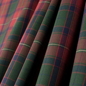May include: Close-up of a red, green and blue plaid fabric. The fabric has a woven texture and is folded in a way that shows the different colours and patterns.