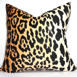 Pu&ograve; includere: Un cuscino decorativo con un motivo leopardato nero, arancione e bianco.