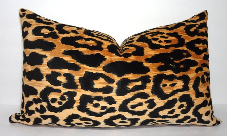 Puede incluir: Una almohada decorativa con un estampado de leopardo en negro, marr&oacute;n y beige.