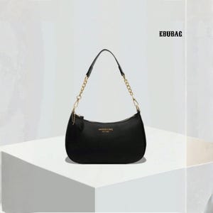 May include: A black shoulder bag with a curved design and a gold chain strap. The bag features a zip closure and a small tag. The text "EBUBAG" is visible in the upper right corner.