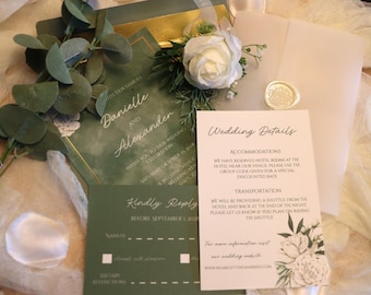 May include: Wedding invitation suite featuring green and gold stationery. Includes invitation, RSVP card, and details card with floral accents. A white rose and eucalyptus sprigs add a natural touch. The invitation reads "Danielle and Alexander".