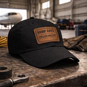 May include: A handmade wooden sign with the text "Welcome" in a handwritten style. The sign is painted white with a distressed finish, and a small green leaf is attached to the top. The sign is designed for indoor or outdoor use.