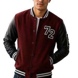 May include: A burgundy and black varsity jacket with the number 72 in white on the chest. The jacket has black leather sleeves, a white collar, and white stripes on the cuffs and hem. The person is wearing blue jeans.