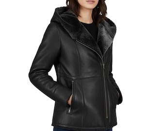May include: A black hooded jacket with a faux fur-lined hood and interior. The jacket features a zipper closure, side pockets, and a tailored fit. The model is wearing blue jeans.