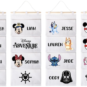 以下が含まれることがあります： 木製のダボが付いた、4つの白い吊り下げ式オーガナイザー。各オーガナイザーには、アンドレア、リアム、ジェシー、お父さんなどの名前とディズニーキャラクターのグラフィックが入った4つのポケットがあります。オーガナイザーは収納用に設計されています。
