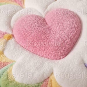 May include: A plush, heart-shaped rug in soft pink, centered within a flower-like design of pastel rainbow colors. The rug has a textured, fluffy appearance, with white, yellow, green, and purple petals. The overall design is whimsical and inviting.