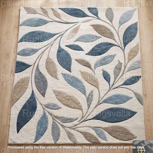 Könnte beinhalten: Rechteckiger Teppich mit cremefarbenem Hintergrund und einem sich wiederholenden Blättermuster in Blau- und Brauntönen. Die Blätter sind in einem fließenden, symmetrischen Design angeordnet, was eine natürliche und elegante Ästhetik schafft. Der Teppich besteht aus weichem, strukturiertem Material.