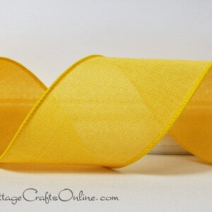May include: Close-up of a bright yellow ribbon with a textured weave and a stitched edge. The ribbon is curled, showing its form and texture. The text "Cottage Crafts Online.com" is visible at the bottom.