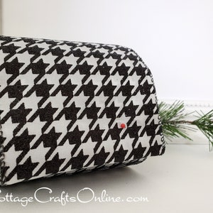 May include: A roll of wired ribbon featuring a black and white houndstooth pattern with a glittery texture on the black sections. The ribbon has a frayed edge and a single small red pin inserted into the fabric. The text CottageCraftsOnline.com is visible.