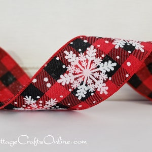 May include: A wired ribbon featuring a red and black buffalo check pattern with white printed snowflakes and small white dots. The ribbon is arranged in a gentle wave, showcasing the textured fabric and the repeating winter-themed design.