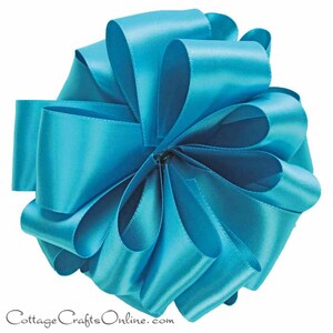 May include: A turquoise satin ribbon bow. The bow is made of multiple loops of ribbon, creating a full and fluffy look.