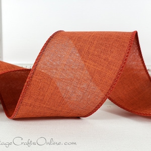 May include: A roll of rust-colored burlap ribbon with a wired edge. The ribbon has a subtle texture and is perfect for crafting and decorating.