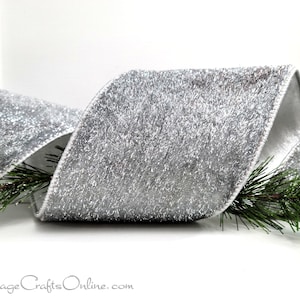 May include: A wide silver ribbon with a textured, glittery surface and metallic sheen, folded into a loop. The ribbon is accented with green pine needles at the base. The text CottageCraftsOnline.com is printed at the bottom of the image.