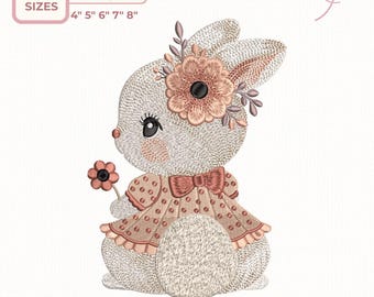 May include: An embroidered design of a bunny wearing a dress and holding a flower. The design includes sizes 4", 5", 6", 7", and 8". The bunny has a flower in its hair and a bow on its dress. The design is in shades of pink, beige, and black.