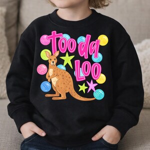 K&ouml;nnte beinhalten: Schwarzes Sweatshirt mit einem Cartoon-K&auml;nguru und dem pinkfarbenen Text "Tooda Loo". Das Design beinhaltet bunte Sterne und Punkte. Das K&auml;nguru ist braun mit wei&szlig;em Bauch.