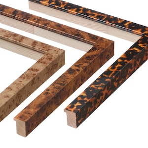 May include: Close-up of three picture frames with different wood grain patterns. The frames are made of wood and have a natural finish. One frame has a light brown burl wood pattern, another has a medium brown burl wood pattern, and the third has a tortoiseshell pattern.