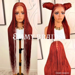 May include: A collection of red braided wigs displayed on a mannequin head. The wigs are styled in different ways, including long, flowing braids and space buns. The text "EMMY BRAIDS" is visible on the image.