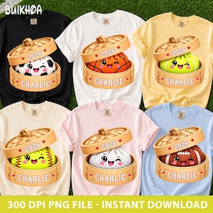 May include: Six t-shirts in black, white, yellow, cream, pink, and light blue, each featuring a graphic of a bamboo steamer basket containing a sports ball character with a face, the text 2026, and the name CHARLIE printed on the base.