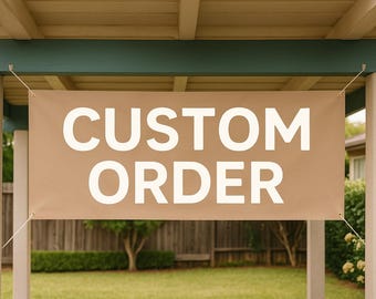 以下が含まれることがあります： 大きな白い大文字で「CUSTOM ORDER」という文字が書かれた、ベージュ色のバナー。バナーは屋外に吊り下げられており、白い柱と緑の屋根のある構造物に固定されています。背景には芝生、木、木のフェンスがあります。