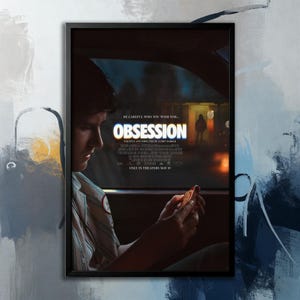 May include: A framed movie poster for "Obsession" with a black border. The poster features a man in a car, holding an object. The title "OBSESSION" is prominently displayed, with the tagline "BE CAREFUL WHO YOU WISH FOR..." and the release date.
