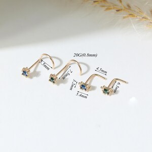 May include: Four gold-tone nose studs with square-cut blue and green gemstones. The studs feature a 20G (0.8mm) gauge. Labeled dimensions include 5.5mm, 7.5mm, 3.2mm, 5.4mm, 4.5mm, and 6.5mm, indicating various post lengths and stone settings.