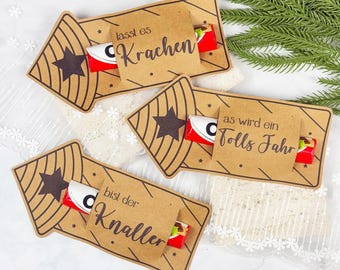 Puede incluir: Etiquetas de regalo de papel kraft con un diseño de estrella y las frases "lasst es Krachen", "as wird ein tolls Jahr" y "bist der Knaller". Cada etiqueta contiene una pequeña barra de chocolate. Las etiquetas están decoradas con pequeñas estrellas y líneas.