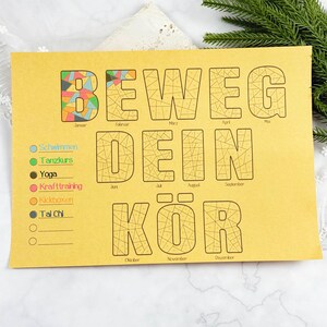 May include: A yellow paper with the German text "BEWEG DEIN KÖR" in large letters. The word "BEWEG" has a colorful geometric design. Below are exercise options: Schwimmen, Tanzkurs, Yoga, Krafttraining, Kickboxen, and Tai Chi.